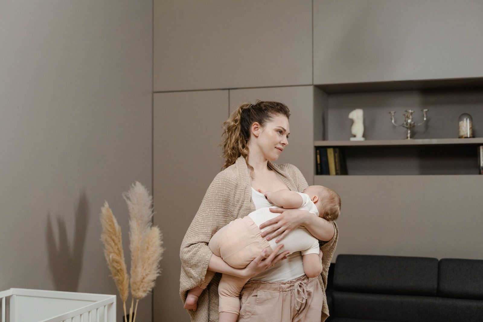 A mother holding and nursing her baby in a quiet living room