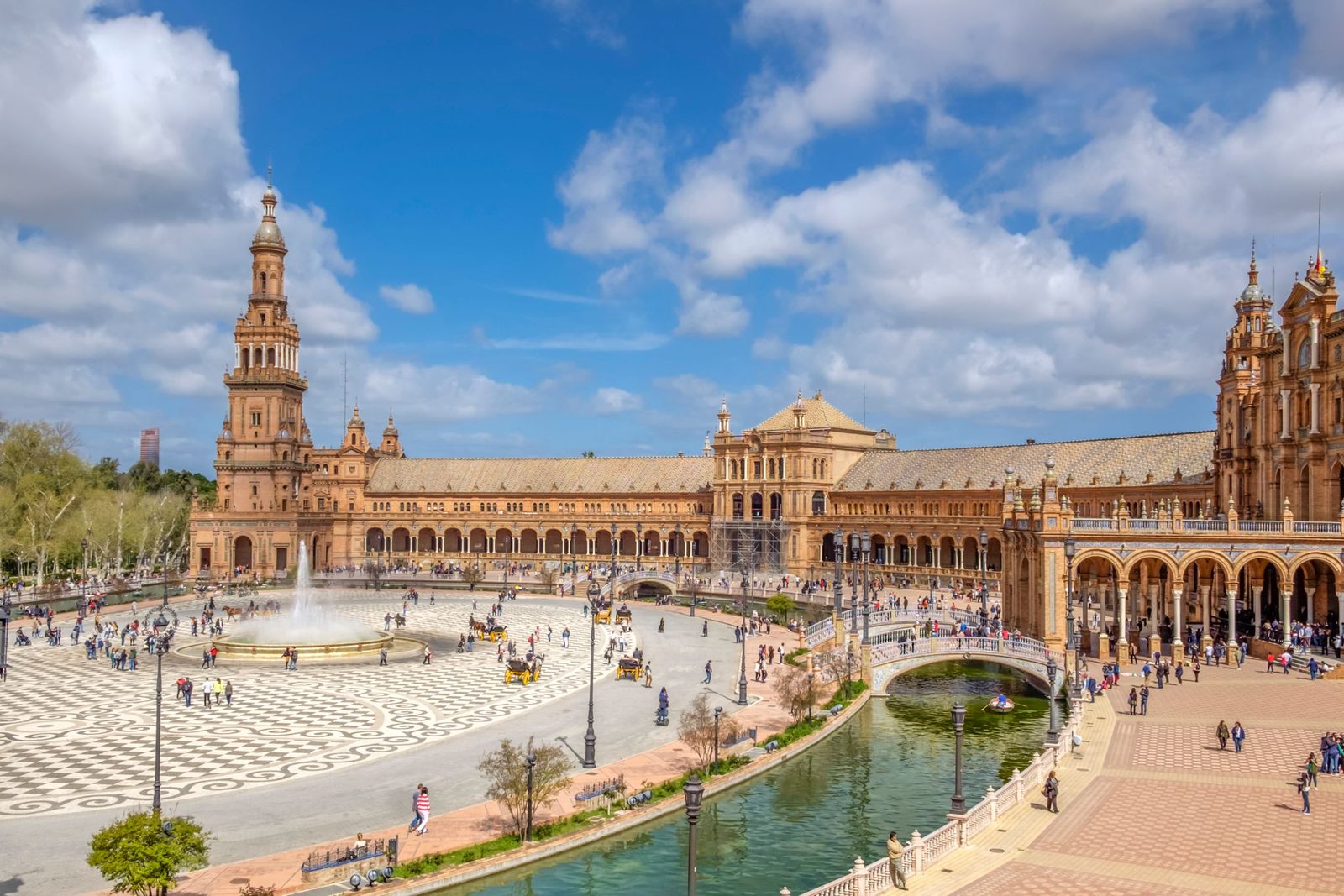 The curved buildings of Plaza de España in Seville under a blue sky