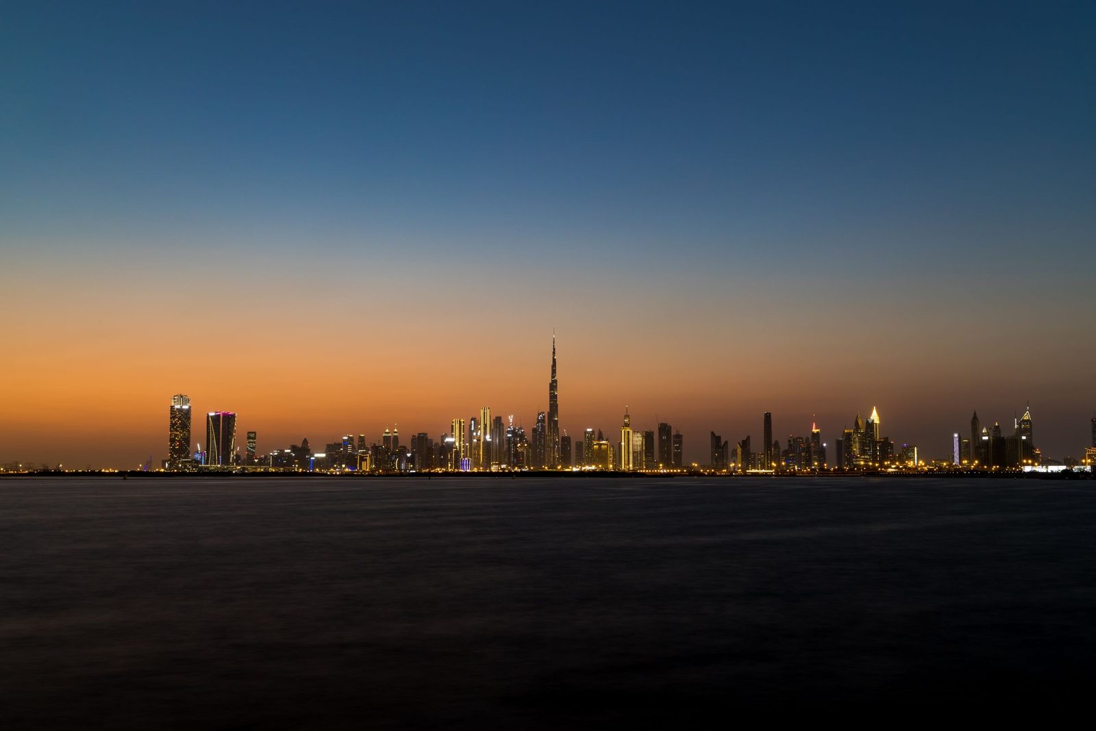 The Dubai skyline and Burj Khalifa across the water at dusk
